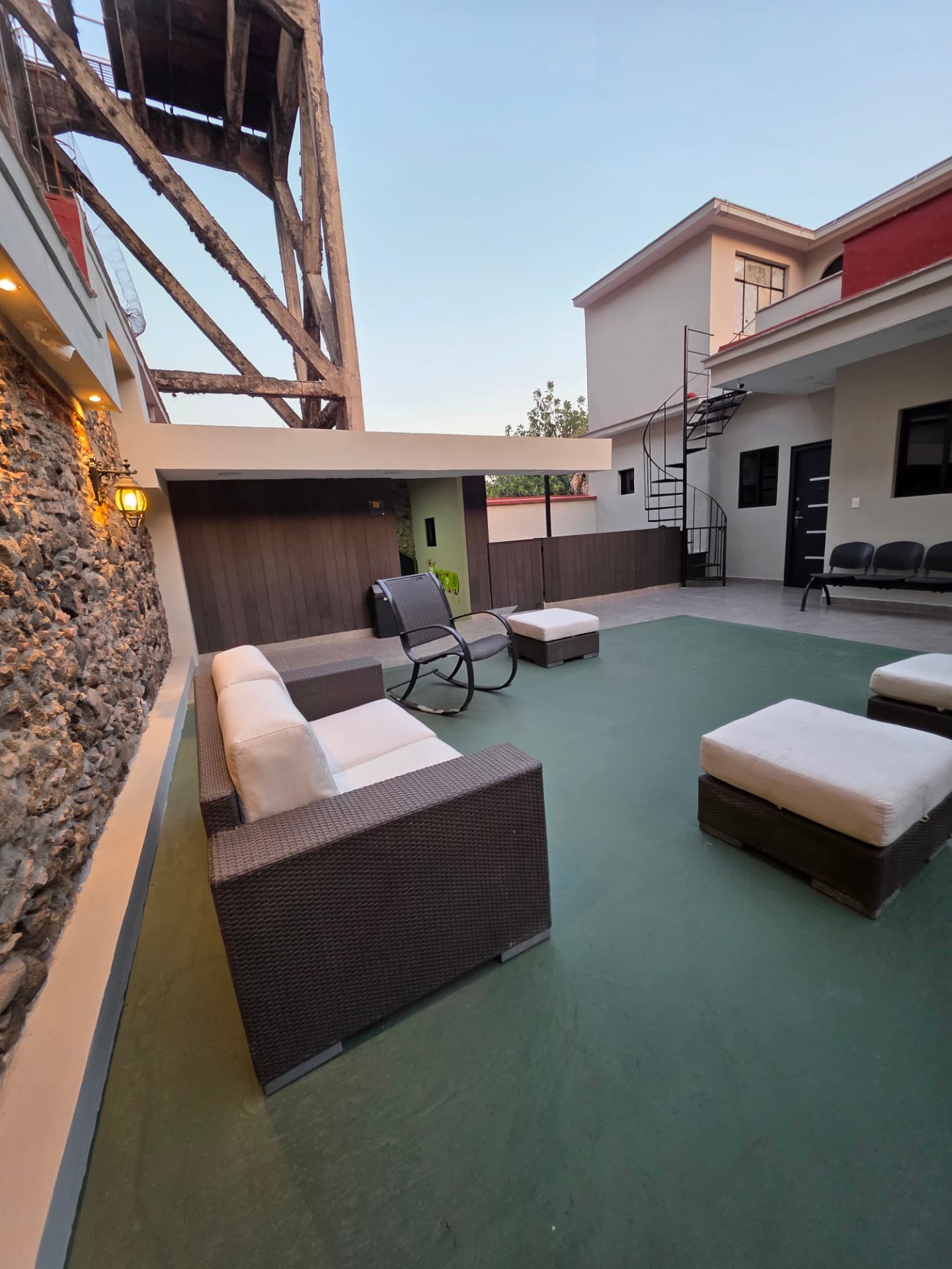 Terraza con sillones exteriores y escalera de caracol